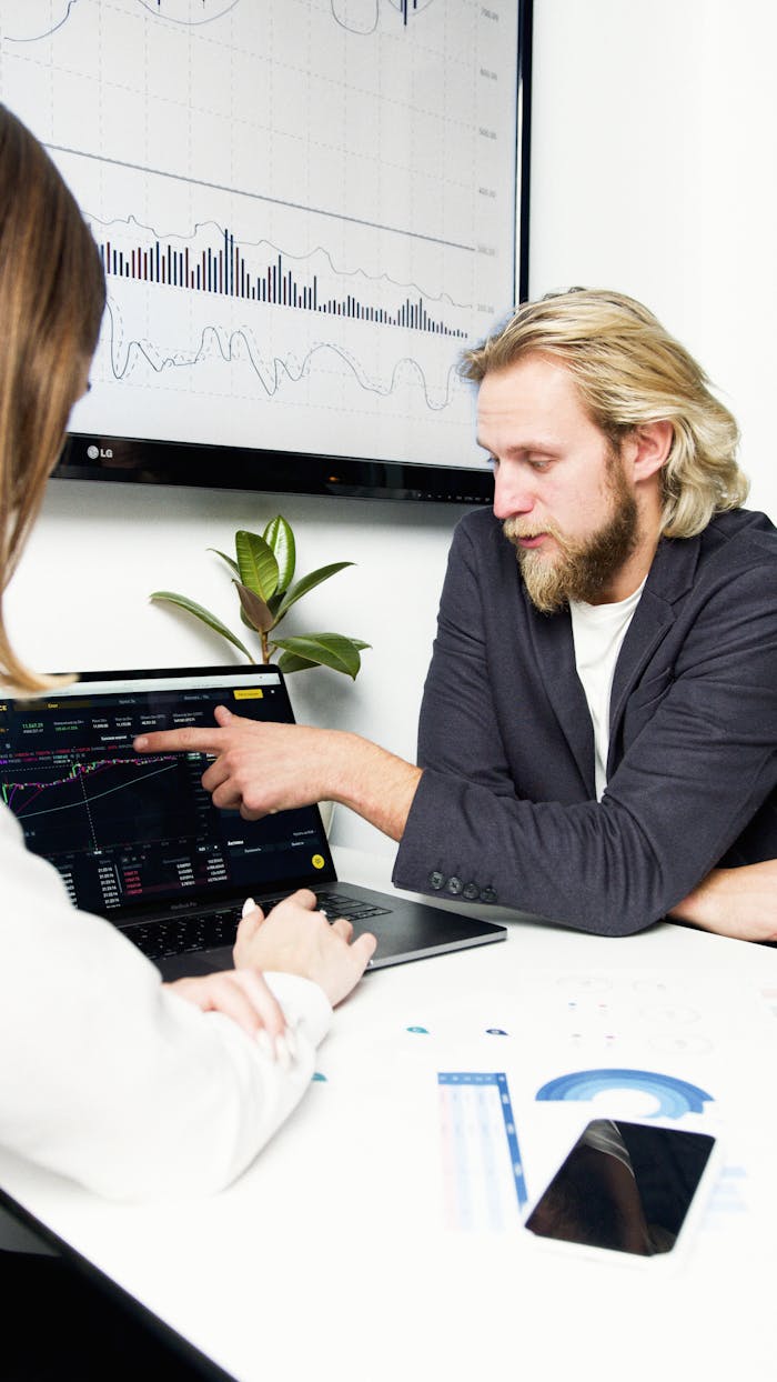 Professionals discussing financial charts and graphs during a business meeting.